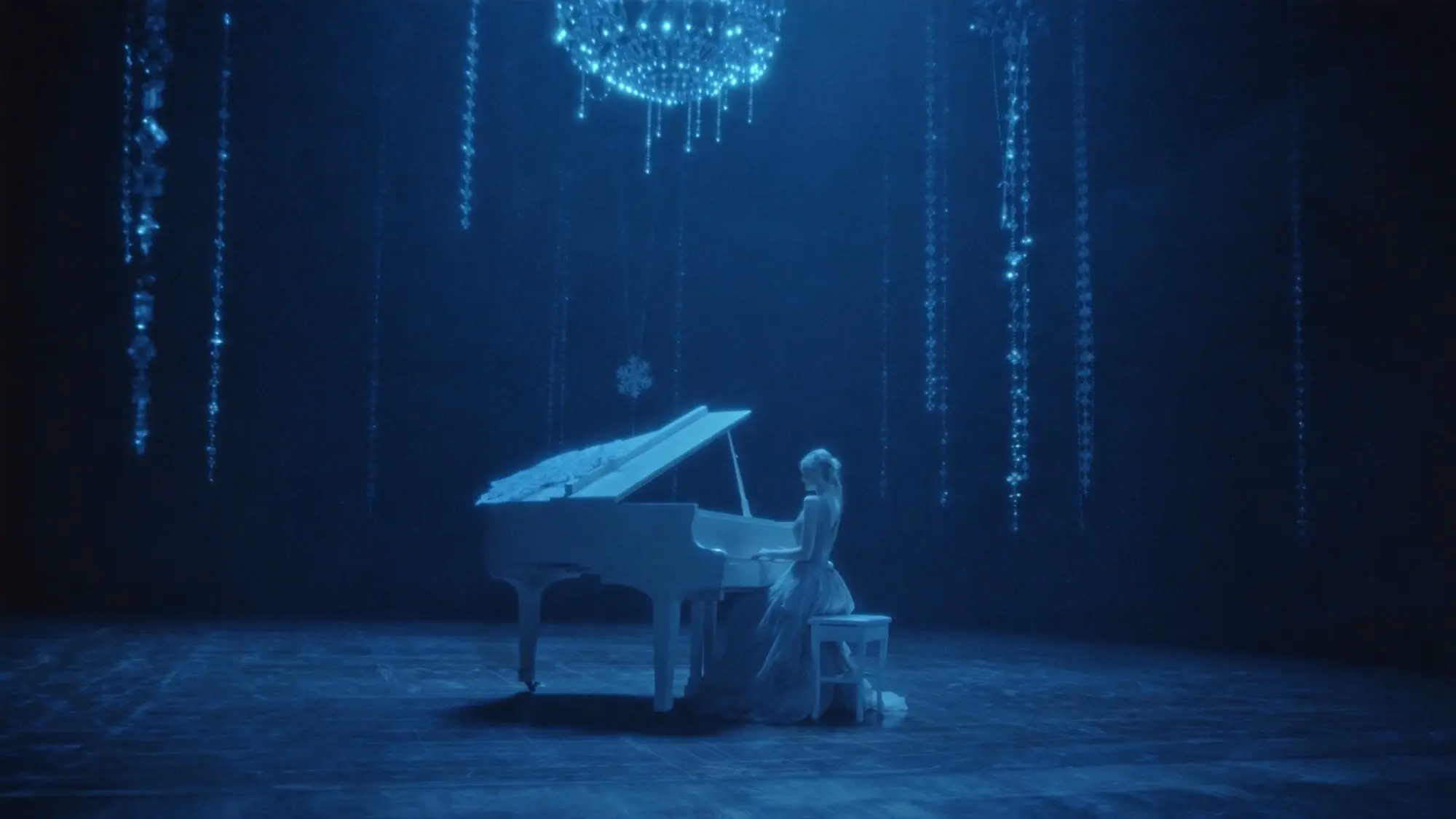 Blue-lit pianist performing on a quiet stage